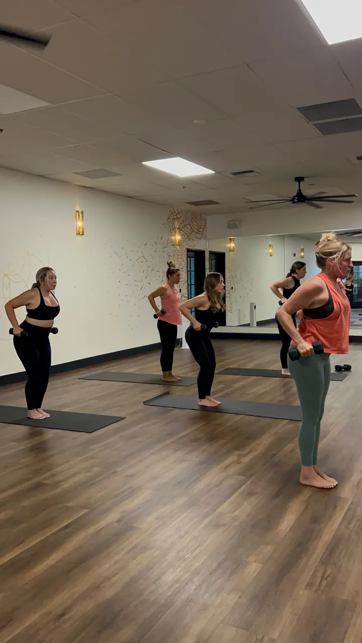 The instructor and class practicing side by side in the warm Roseville studio