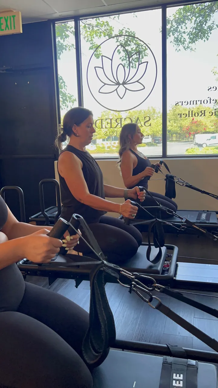 Two reformers set beside the window signage for reformer and lymphatic roller sessions