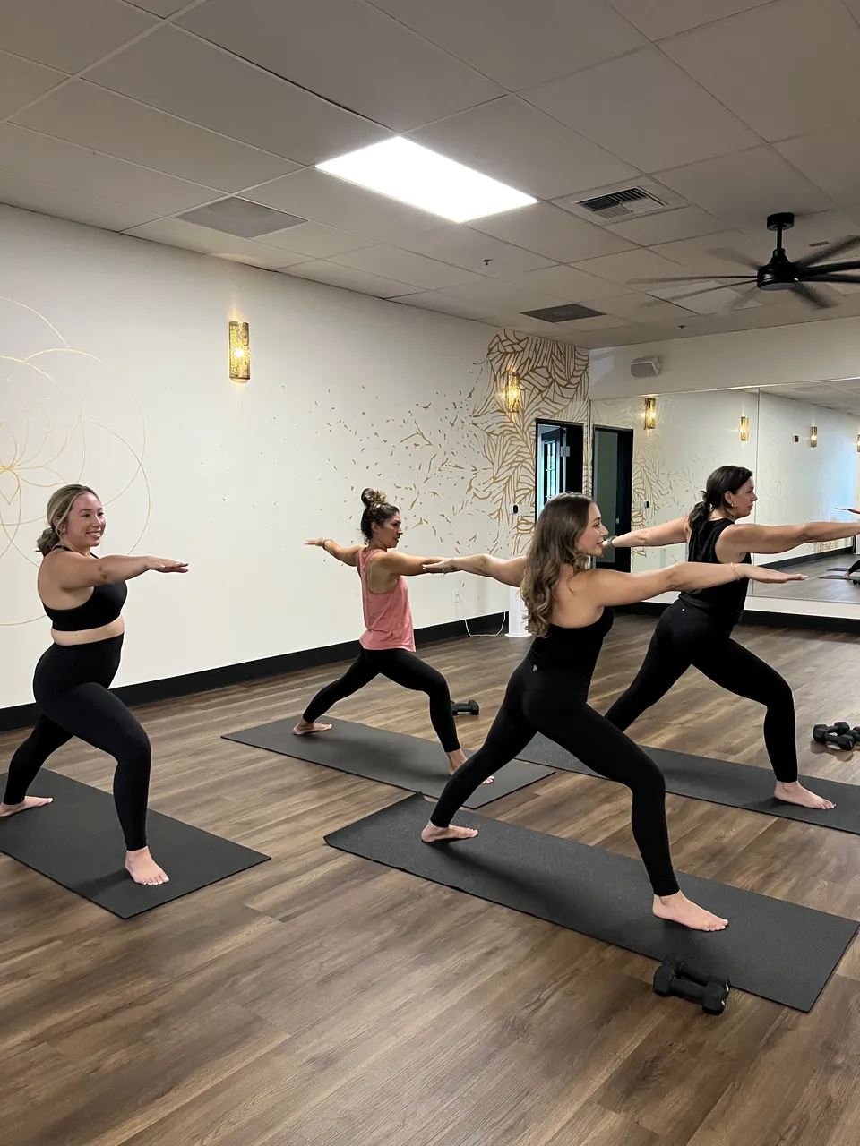 A wide view of the hot yoga class in triangle pose together